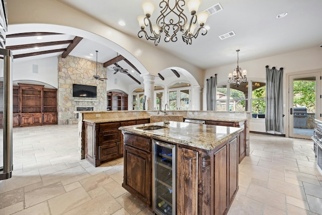 kitchen featuring a large island, beverage cooler, lofted ceiling with beams, and hanging light fixtures