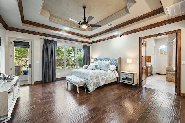 bedroom featuring ceiling fan, access to outside, dark hardwood / wood-style floors, and a tray ceiling