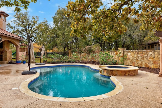 view of pool with an outdoor fireplace, a patio area, and an in ground hot tub