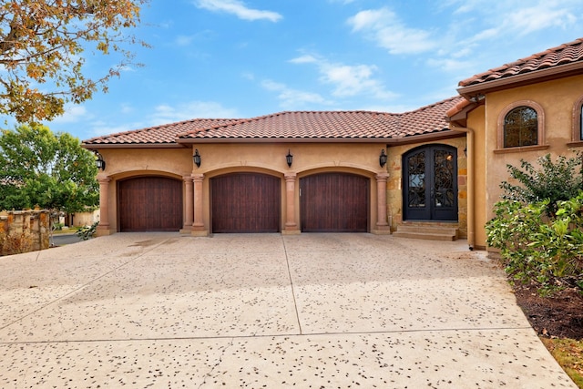 mediterranean / spanish-style house featuring french doors and a garage