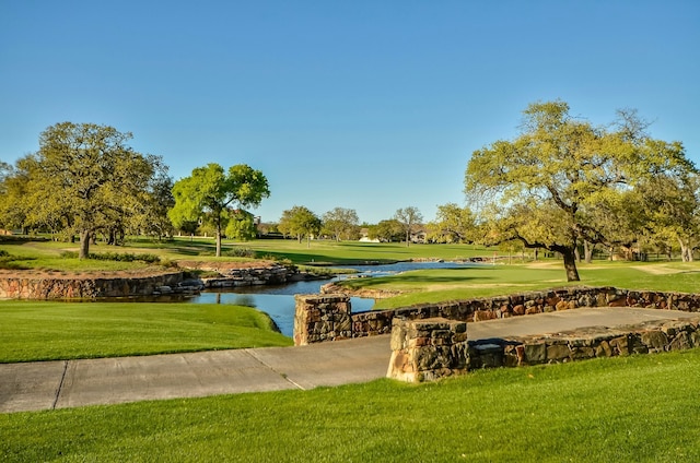 view of property's community with a yard and a water view