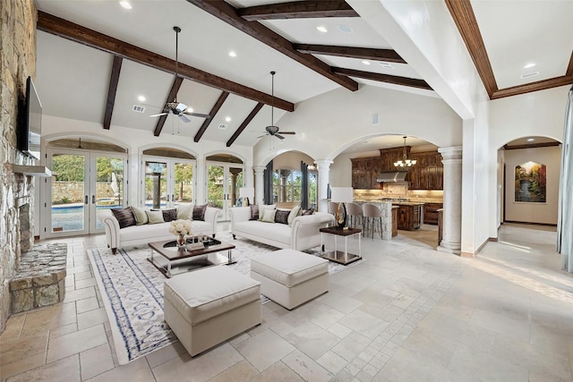 living room with ceiling fan with notable chandelier, high vaulted ceiling, french doors, and a healthy amount of sunlight