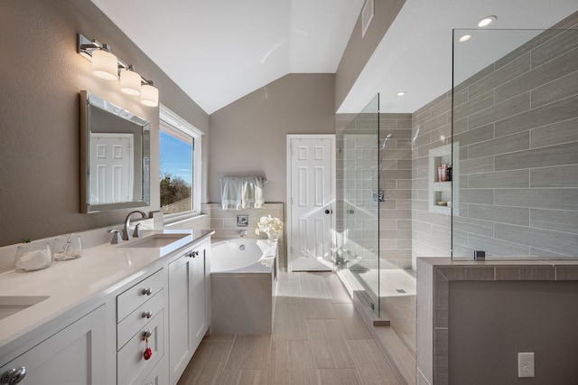 bathroom with shower with separate bathtub, vanity, and vaulted ceiling