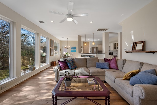 living room featuring wood-type flooring and ceiling fan