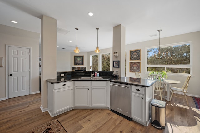 kitchen featuring decorative light fixtures, white cabinets, and sink