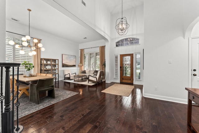 entrance foyer with a high ceiling, hardwood / wood-style flooring, and a chandelier