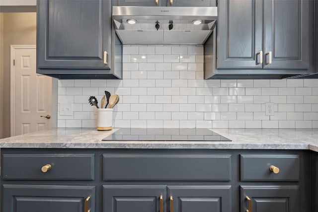 kitchen featuring light stone countertops, extractor fan, tasteful backsplash, black electric cooktop, and gray cabinetry