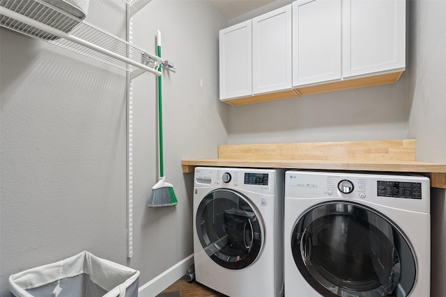 laundry area featuring dark wood-type flooring, cabinets, and independent washer and dryer