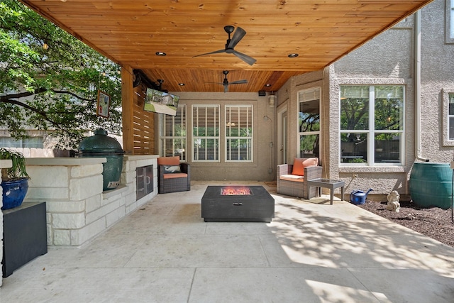 view of patio / terrace featuring exterior kitchen, ceiling fan, a fire pit, and area for grilling