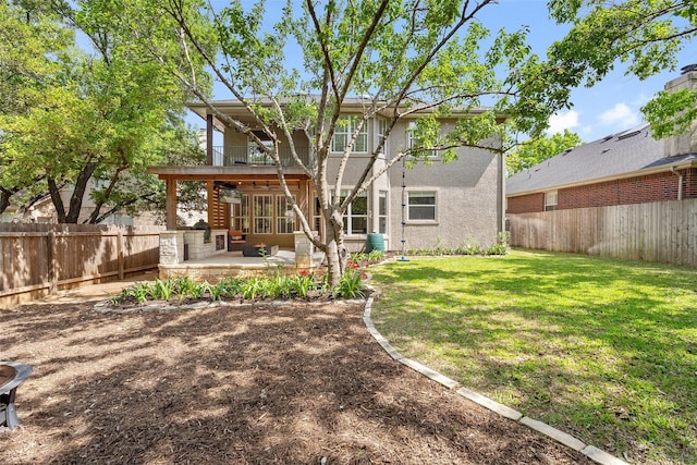 back of property with a balcony, a yard, and a patio area