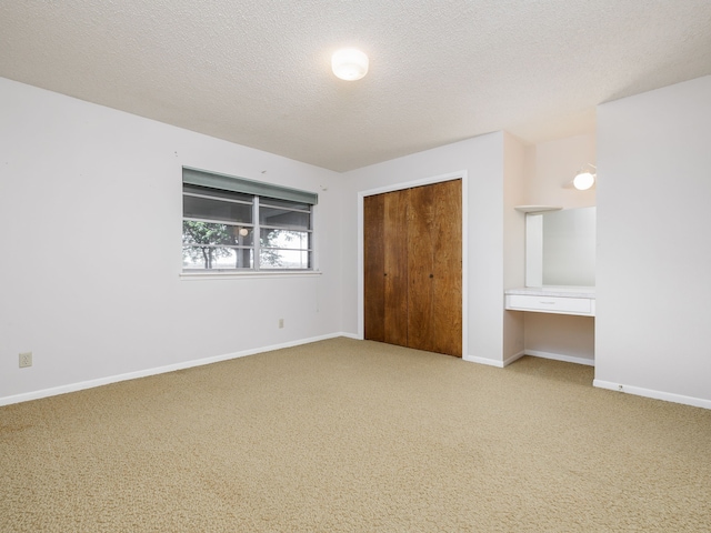 unfurnished bedroom with a textured ceiling, a closet, and carpet flooring