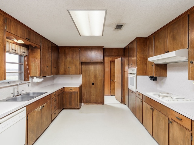 kitchen with white appliances, a textured ceiling, and sink