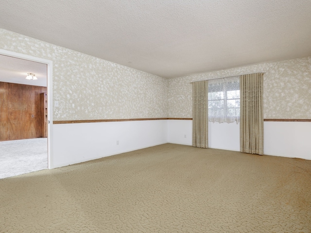 unfurnished room featuring a textured ceiling and carpet flooring