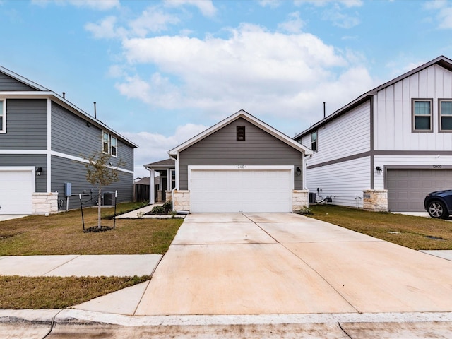 view of front of home with central air condition unit, stone siding, a front lawn, and concrete driveway