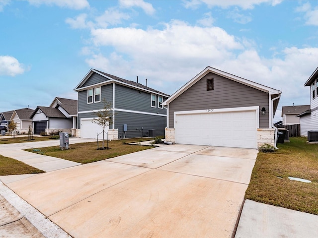 view of front of property with concrete driveway, a front yard, a garage, cooling unit, and stone siding