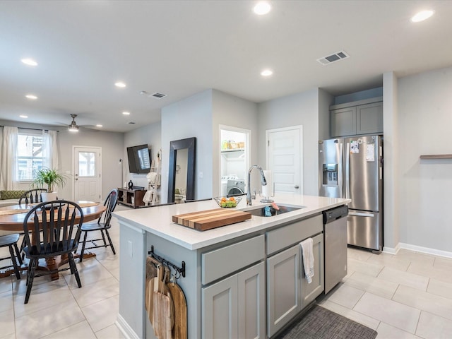 kitchen with light countertops, visible vents, gray cabinetry, appliances with stainless steel finishes, and a sink