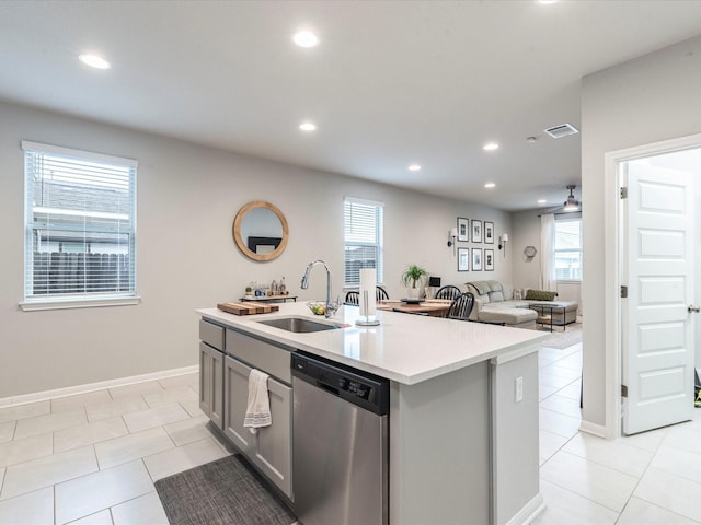 kitchen with gray cabinets, light countertops, visible vents, stainless steel dishwasher, and a sink