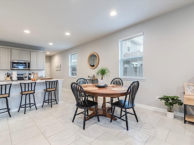 dining space featuring recessed lighting, light tile patterned flooring, and baseboards