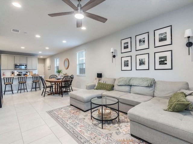 living area with light tile patterned floors, visible vents, a ceiling fan, and recessed lighting