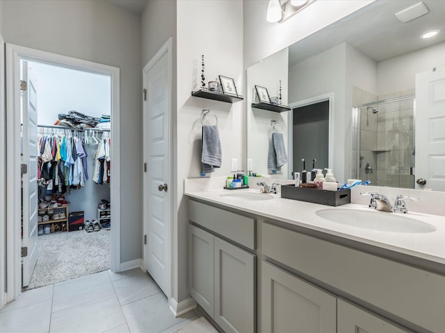 full bathroom with double vanity, a stall shower, a spacious closet, and a sink