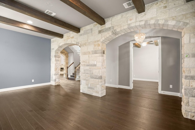 unfurnished living room with ceiling fan, beamed ceiling, and dark wood-type flooring