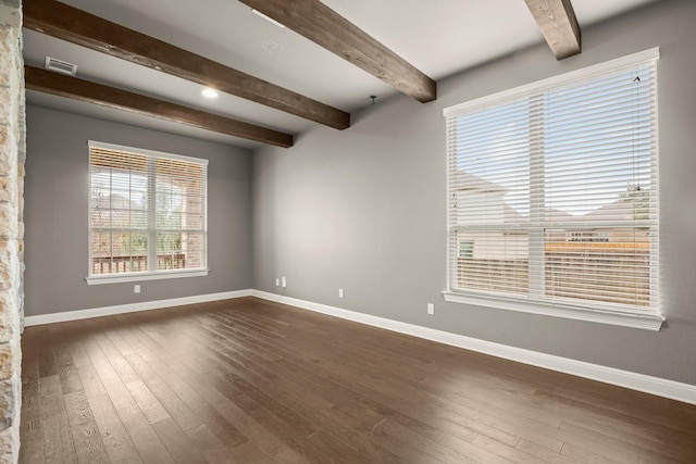 empty room featuring beamed ceiling and dark hardwood / wood-style floors