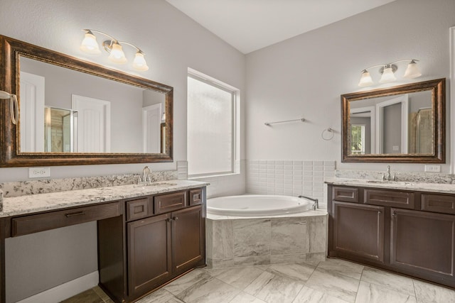 bathroom featuring vanity and tiled bath