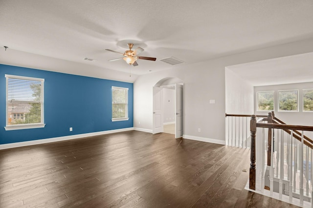 empty room with ceiling fan and dark hardwood / wood-style flooring