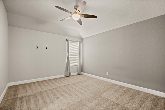 carpeted spare room with lofted ceiling and ceiling fan