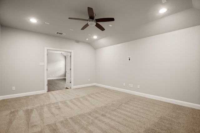 empty room with vaulted ceiling, ceiling fan, and carpet flooring