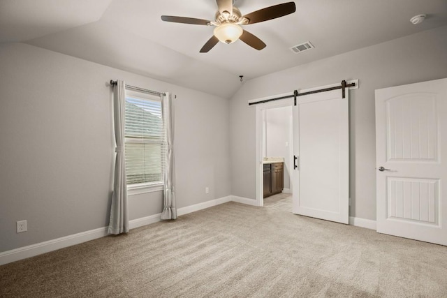 3816 Tango Ct, Leander, TX 78641 - unfurnished bedroom featuring vaulted ceiling, a barn door, light colored carpet, ensuite bath, and a ceiling fan