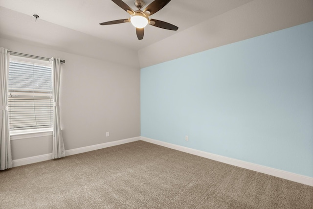 carpeted spare room featuring lofted ceiling and ceiling fan