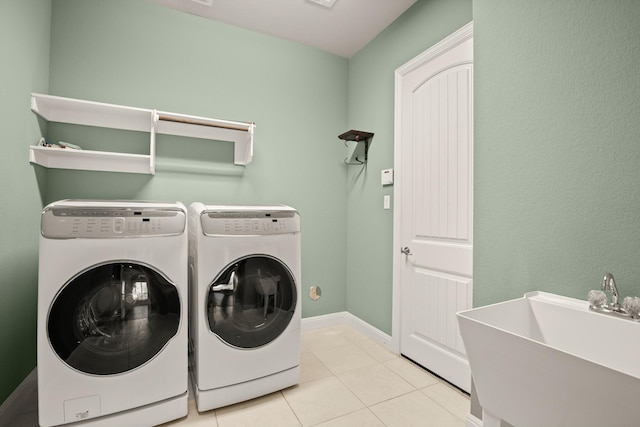 laundry room with independent washer and dryer, light tile patterned floors, and sink