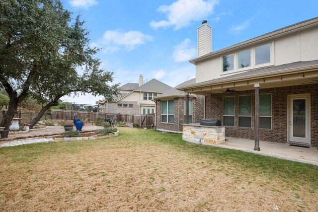 view of yard featuring ceiling fan and a patio