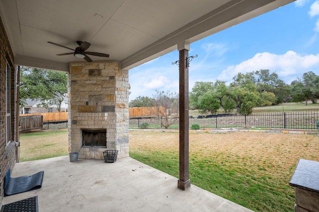 view of patio featuring an outdoor stone fireplace and ceiling fan