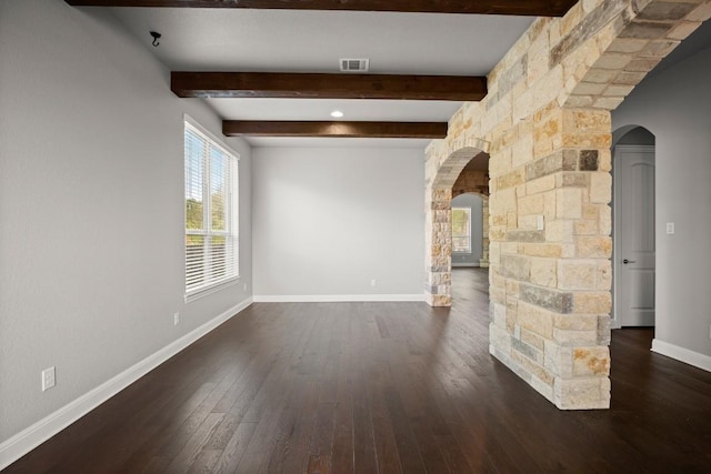3816 Tango Ct, Leander, TX 78641 - empty room featuring arched walkways, dark wood-style floors, and beamed ceiling