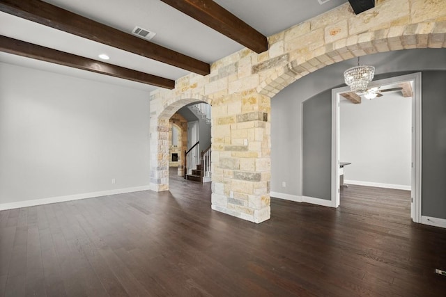3816 Tango Ct, Leander, TX 78641 - unfurnished living room with arched walkways, stairway, wood finished floors, beamed ceiling, and a chandelier
