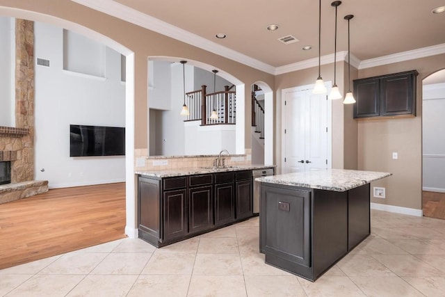 974 Clear Springs Holw, Buda, TX 78610 - kitchen with ornamental molding, a sink, light stone counters, light tile patterned floors, and recessed lighting