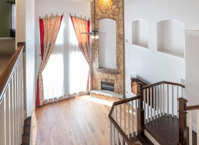 974 Clear Springs Holw, Buda, TX 78610 - unfurnished living room with a stone fireplace, wood finished floors, a ceiling fan, and a towering ceiling