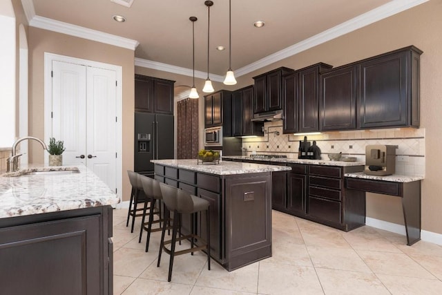 974 Clear Springs Holw, Buda, TX 78610 - kitchen featuring a sink, appliances with stainless steel finishes, a kitchen island, backsplash, and ornamental molding