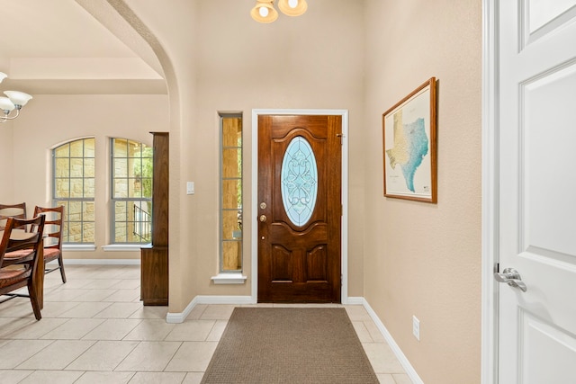 entryway with light tile patterned flooring and a chandelier