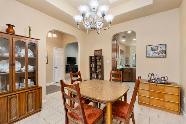 dining area featuring a notable chandelier and light tile patterned flooring