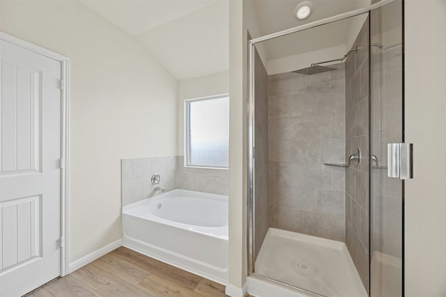 bathroom with separate shower and tub, vaulted ceiling, and hardwood / wood-style flooring