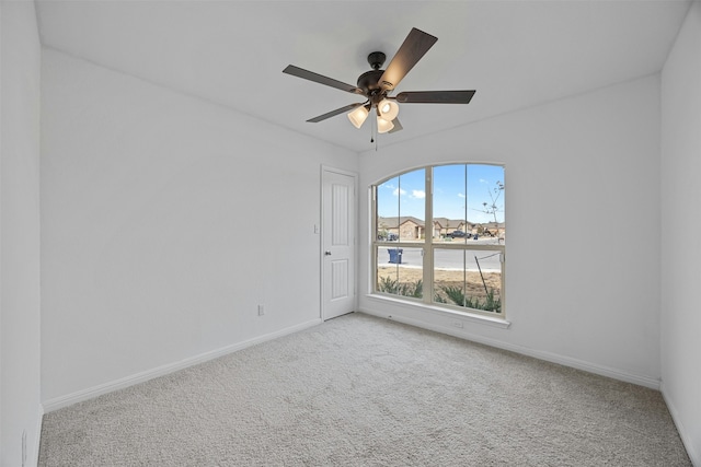 carpeted spare room with ceiling fan