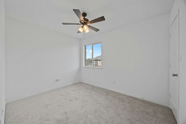 spare room with ceiling fan and light colored carpet