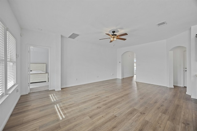 unfurnished living room featuring ceiling fan, plenty of natural light, and light hardwood / wood-style flooring