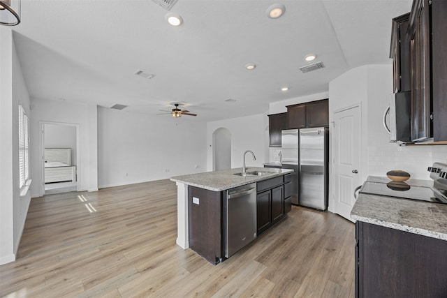 kitchen with tasteful backsplash, ceiling fan, sink, a kitchen island with sink, and stainless steel appliances