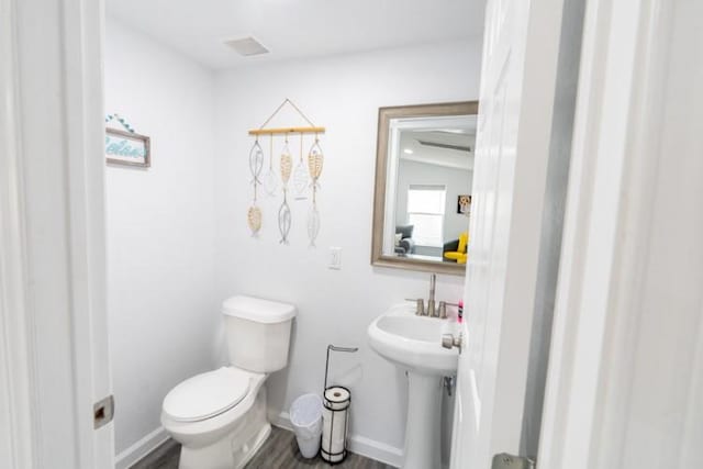 bathroom featuring hardwood / wood-style flooring and toilet