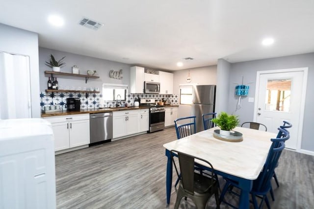 dining space with sink and wood-type flooring