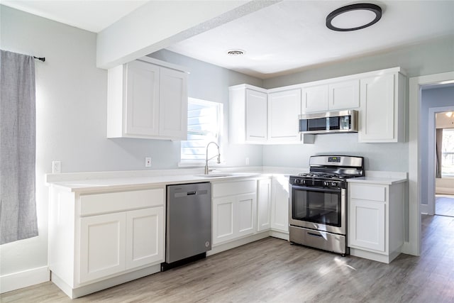 kitchen featuring stainless steel appliances, white cabinets, and a healthy amount of sunlight